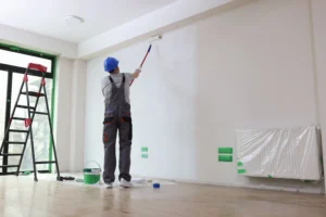 professional-painter-paints-office-wall-with-roller-brush-decoration-improvement-office-min